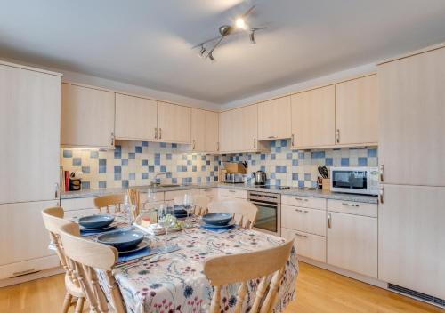 a kitchen with a table and chairs and a kitchen with white cabinets at Elterwater Apartment in Bowness-on-Windermere