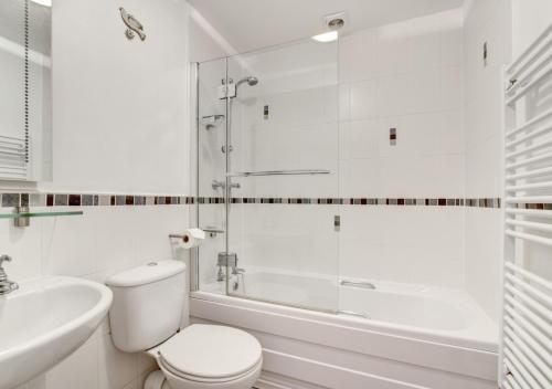 a white bathroom with a toilet and a shower at Elterwater Apartment in Bowness-on-Windermere