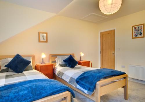 1 dormitorio con 2 camas y 2 mesitas de noche con lámparas en Stanhope en Ulverston