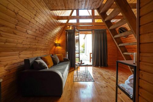 ein Wohnzimmer mit einer Couch in einem Holzhaus in der Unterkunft Mtskheta Cabin in Mzcheta