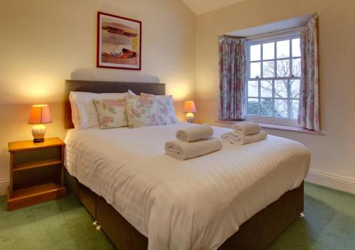 a bedroom with a large bed with towels on it at Tabithas Cottage in Chapel Stile