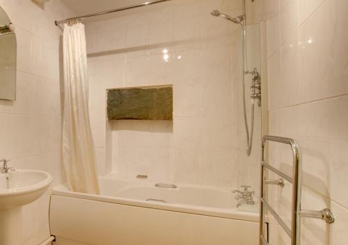 a white bathroom with a tub and a sink at Tabithas Cottage in Chapel Stile