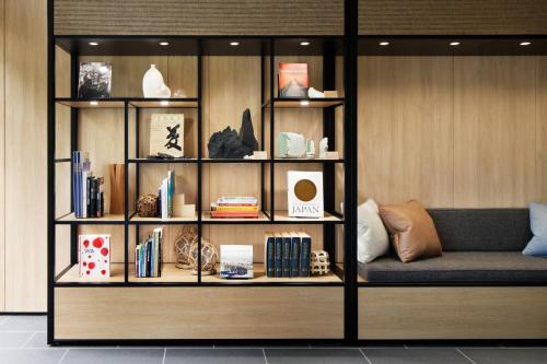 a book shelf filled with books and a couch at Fairfield by Marriott Mie Kumano Kodo Mihama in Mihama