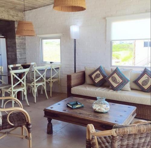 ein Wohnzimmer mit einem Sofa und einem Tisch in der Unterkunft Miralejos in Punta Del Diablo