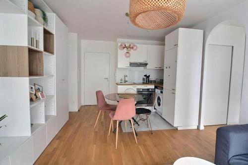 une cuisine avec une table et des chaises dans une pièce dans l'établissement Le Toît du Montvalerien Suresnes, à Suresnes