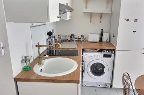 a kitchen with a sink and a washing machine at Le Toît du Montvalerien Suresnes in Suresnes