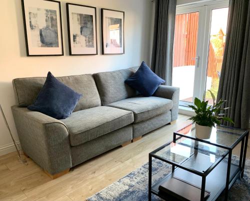 a living room with a couch and a table at 3 bedroom - 2 bathroom Townhouse in Corstorphine Near Murrayfield Stadium - Direct Bus To Edinburgh City Centre in 20 Minutes - Two Private Parking Spaces - Private Sunny Garden - Recently Refurbished in Edinburgh