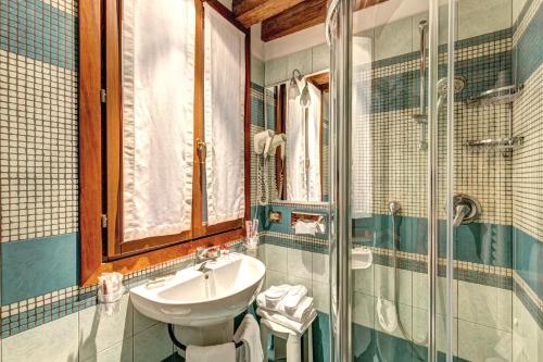 W łazience znajduje się umywalka i prysznic. w obiekcie Palazzo La Scala w Wenecji