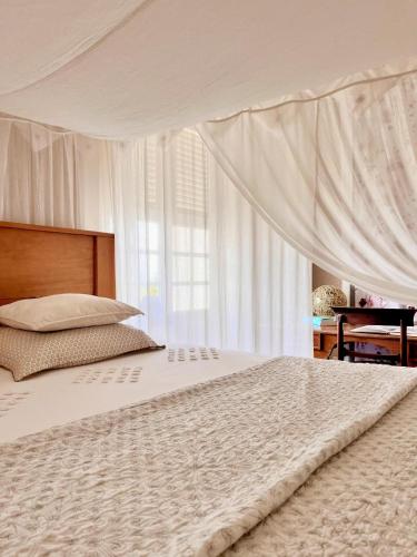 a bedroom with a large bed with a canopy at Habitation La Reine du Camp Chambres d'Hôtes in Saint-Claude