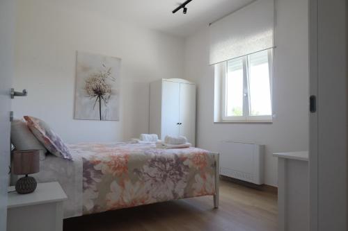 - une chambre blanche avec un lit et une fenêtre dans l'établissement Malia Holiday Villa, à Conversano