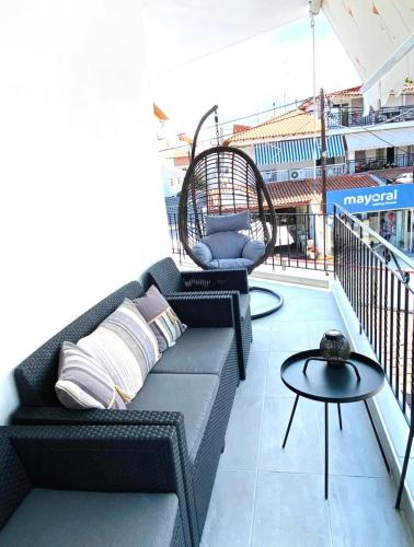 a rooftop patio with a couch and a table at Jasmin Apartments in Hanioti