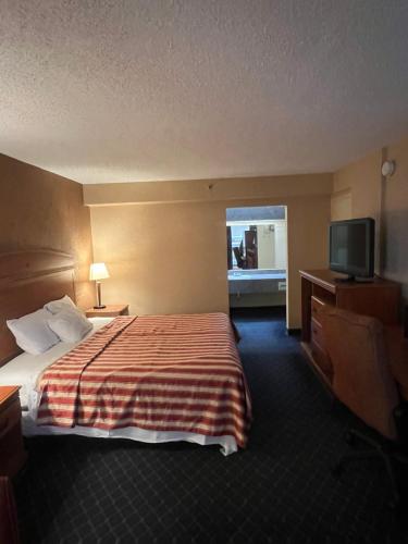 a hotel room with a bed and a flat screen tv at The Lodge Hotel and Banquets in Bridgeton