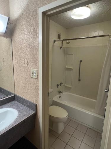 a bathroom with a tub and a toilet and a sink at The Lodge Hotel and Banquets in Bridgeton