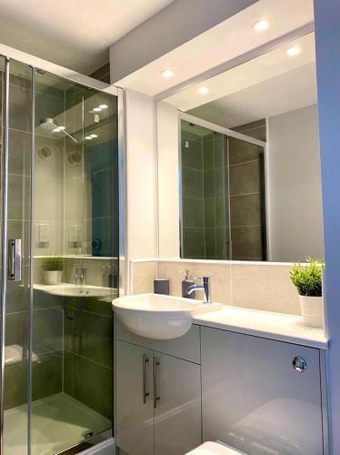 a bathroom with a sink and a glass shower at 3 bedroom - 2 bathroom Townhouse in Corstorphine Near Murrayfield Stadium - Direct Bus To Edinburgh City Centre in 20 Minutes - Two Private Parking Spaces - Private Sunny Garden - Recently Refurbished in Edinburgh