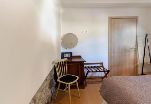 a bedroom with a desk and a bed and a chair at 1951 Suites in Kalabaka