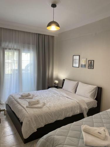 a bedroom with two beds and a window at Sweet Home Ano Poli in Thessaloniki