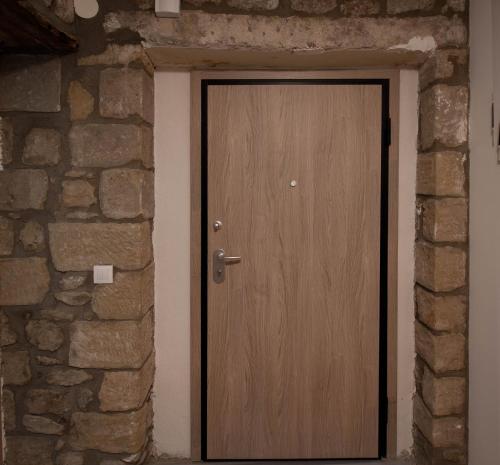 a wooden door in a brick wall at 1951 Suites in Kalabaka
