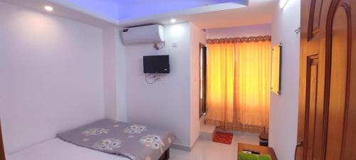um pequeno quarto com uma cama e uma janela em Hotel Prime Inn Mirpur 10 em Daca