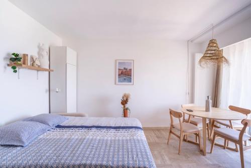 a bedroom with a bed and a table and chairs at Grand Studio 38m2 vue Mer et Parking ! in Hyères