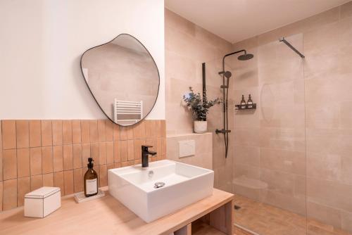 a bathroom with a white sink and a mirror at Grand Studio 38m2 vue Mer et Parking ! in Hyères