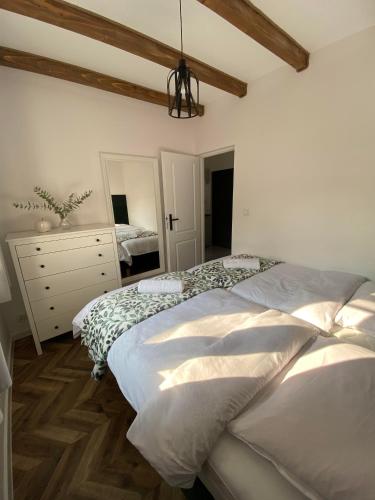 a bedroom with two beds and a dresser at Zajęcza Nora, balia ogrodowa in Polańczyk