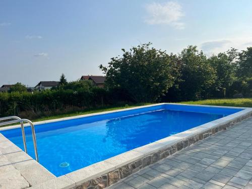 a swimming pool with blue water in a yard at Kuća za odmor Dugo Selo M&A in Dugo Selo