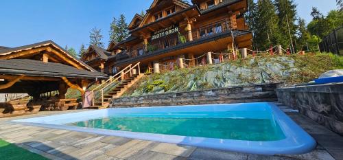 a swimming pool in front of a house at Apartamenty Złoty Groń in Istebna