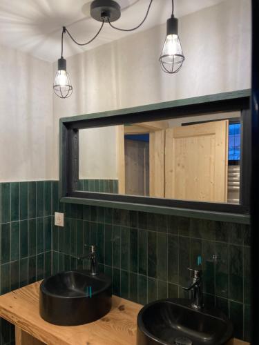 a bathroom with two sinks and a mirror at Maison La Tourelle in Baume-les-Dames