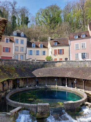 un grand bassin d'eau dans une ville avec des bâtiments dans l'établissement La Ferme de Victor - Maison de village, à Coussegrey