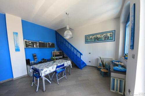 a blue room with a table and a blue staircase at La Casa Sulla Spiaggia in Flumini di Quartu
