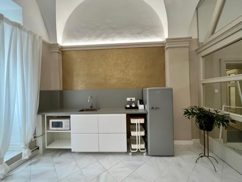 a kitchen with a refrigerator in a room at Palác Daun - Studio Apartments in Znojmo