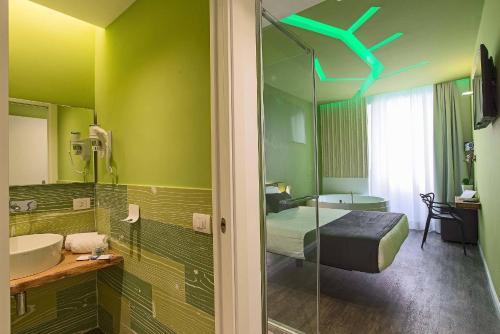 een groene badkamer met een bed en een wastafel bij Ripetta Relais in Rome