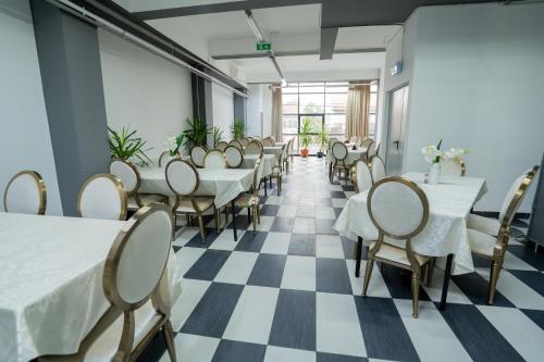 a restaurant with tables and chairs on a checkered floor at HOTEL N Residence in Timişoara