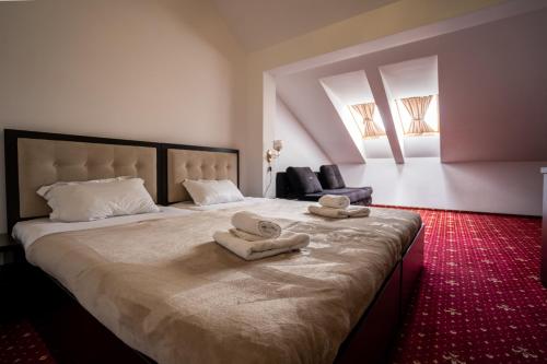 a bedroom with a large bed with two towels on it at HOTEL N Residence in Timişoara