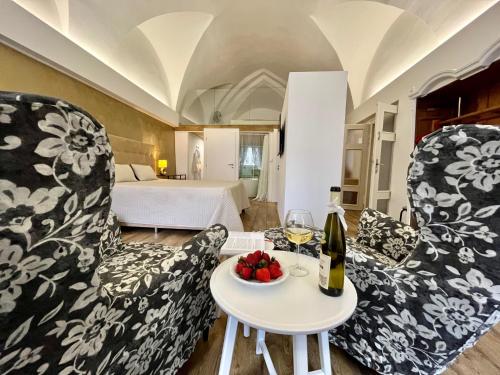 a room with two chairs and a table with a bottle of wine at Palác Daun - Studio Apartments in Znojmo