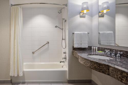 a bathroom with a tub and a sink and a shower at Le Meridien Dallas by the Galleria in Dallas