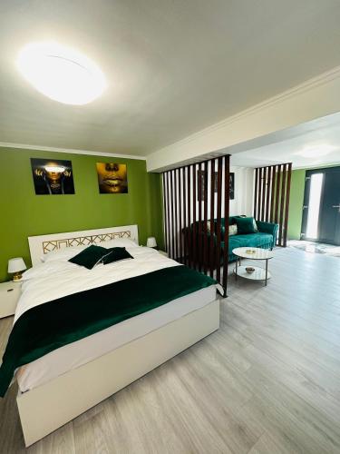 a bedroom with a large bed and a green wall at Luxor Apartament Sibiu in Sibiu