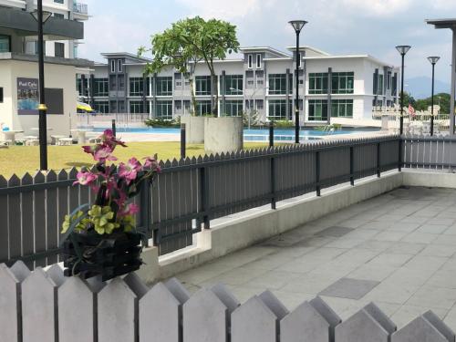 une clôture blanche avec un vase de fleurs à côté d'un bâtiment dans l'établissement Meru Oasis at Casa Kayangan Ipoh, à Ipoh