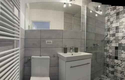 a white bathroom with a sink and a toilet at Easy Living Apartments - Old Town in Braşov