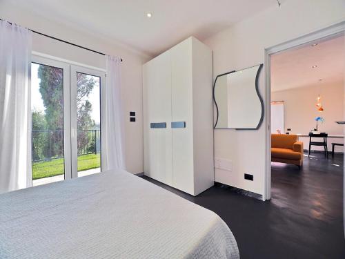 a white bedroom with a large bed and a mirror at La Valle Incantata in Lerici