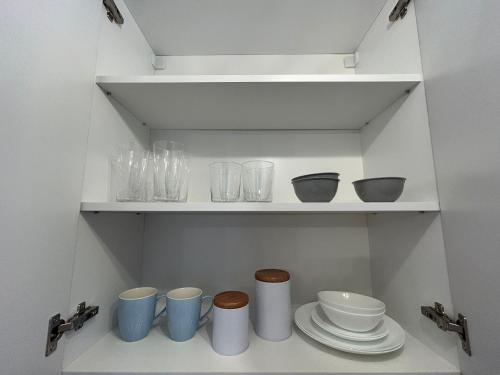 a shelf with bowls and other dishes on it at Easy Living Apartments - Old Town in Braşov