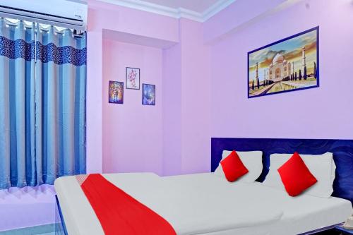 a bedroom with a bed with red pillows at Super Hotel O New View in Bankipur