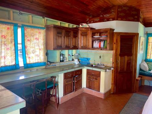 uma cozinha com armários de madeira e uma bancada em Treehouse Apartment at La Lodge at Long Bay em Ilhas do Milho
