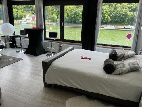 - une chambre avec un grand lit et une grande fenêtre dans l'établissement Entre Roche & Meuse, à Hastière-par-delà