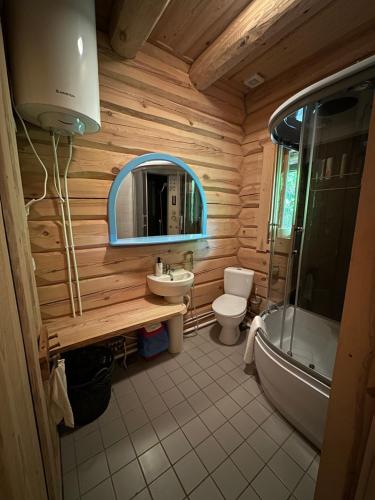 baño con cabina de madera con aseo y lavamanos en Quiet Log House, Vaikne palkmaja, Kevadekuulutaja, Harbinger of spring, en Rannaküla