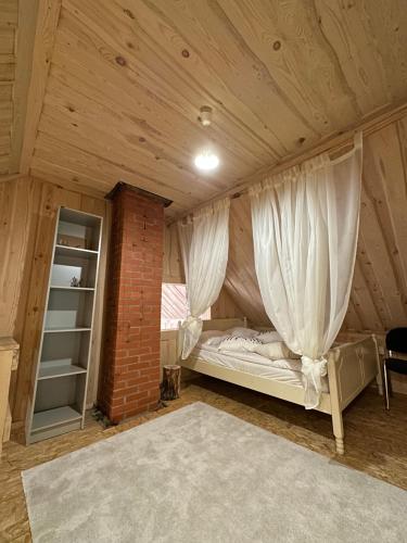 a bedroom with a bed with curtains in a attic at Quiet Log House, Vaikne palkmaja, Kevadekuulutaja, Harbinger of spring in Rannaküla