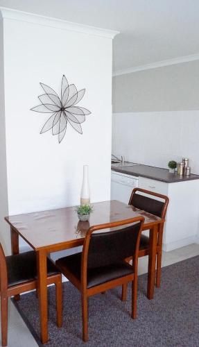 a dining room table with two chairs and a table and a kitchen at Maude St Apartments in Shepparton