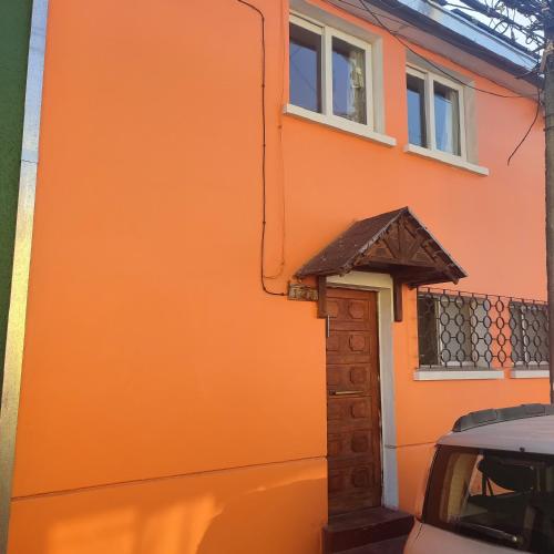 an orange building with a small door on the side of it at Gatos de campo, tiernos y traviesos in Santiago