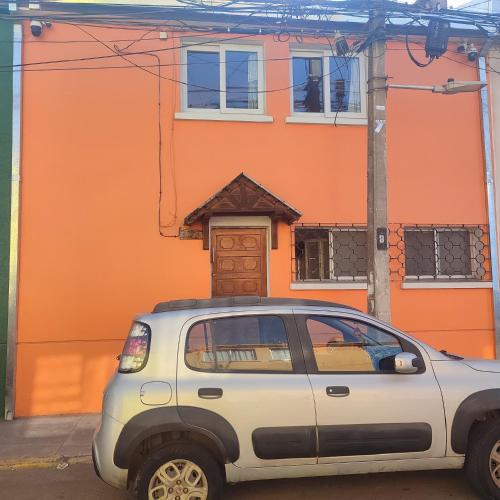 a car parked in front of an orange building at Gatos de campo, tiernos y traviesos in Santiago
