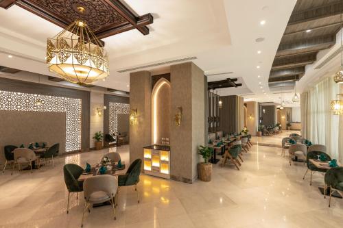 a restaurant with tables and chairs and a chandelier at Gewan Resort New Alamein in El Alamein